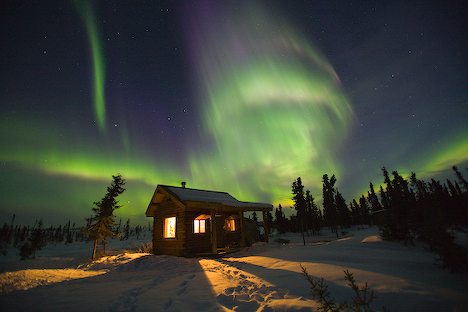 Northern Lights dance over a cabin in Fairbanks