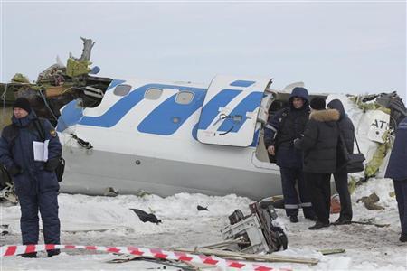 Emergency service workers investigate the wreckage of the UTair airlines ATR 72 passenger plane that crashed near the Siberian city of Tyumen