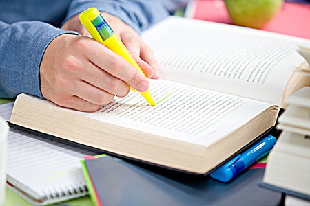 Close-up of a serious male teenager studying in the cafeteria