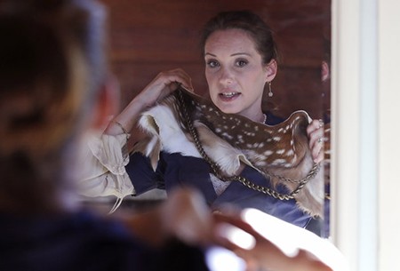 Pam Paquin tries on a fawn scarf and belt at her home in Central Massachusetts, Wednesday, Nov. 18, 2015. Paquin's source for fashion is either tres chic or will make you shriek: She creates muffs, wraps and scarves from road kill _ "accidental fur," as Paquin puts it. Her company, Petite Mort, uses roadkill fur harvested from animal carcasses culled with the help of highway departments and animal control officers. (AP Photo/Charles Krupa)