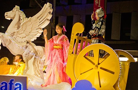 Two Chinese girls in traditional costume ride a cart drawn by flying-horse. They took role in the Chinese New Year Twilight Parade, celebrating the year of horse. This parade is a part of Chinese New Year Festival 2014 in Sydney. Information about the related event is available here: http://www.sydneychinesenewyear.com/festival-program/chinese-new-year-twilight-parade/.